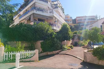 a white fence in front of a building at Refurbished apartment with terrace and garden in Nice