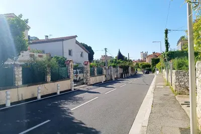 an empty street with houses and a fence at Refurbished apartment with terrace and garden in Nice