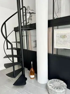 a bottle of wine on the floor next to a spiral staircase at Magnifique loft au cœur de Nice in Nice