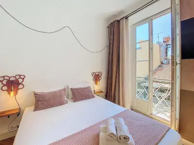 a bedroom with a bed and a window with towels on it at Nestor&Jeeves - CITY TRIP - Central - Balcony in Nice