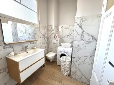 a bathroom with a sink and a washing machine at ApartHotel Riviera - TERRASSE HORIZON - 15' Promenade des Anglais in Nice