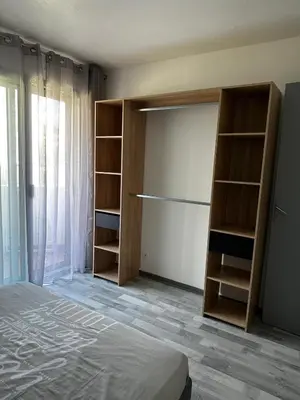 a bedroom with a bed and a closet with shelves at Californie in Nice