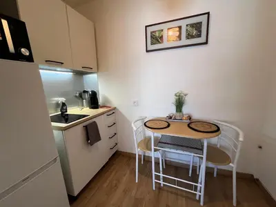 a small kitchen with a small table and chairs at Studio proche promenade des anglais in Nice