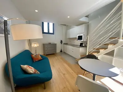 a living room with a blue couch and a table at Studio Beautes FSHH in Nice