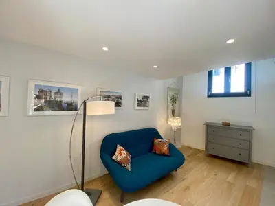 a living room with a blue chair and a lamp at Studio Beautes FSHH in Nice