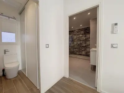 a bathroom with a toilet and a stone wall at Nestor&Jeeves - BRISE DE NICE - Balcony - Central in Nice