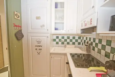 a kitchen with white cabinets and green and white tiles at Villa Rivoli City Center Nice in Nice