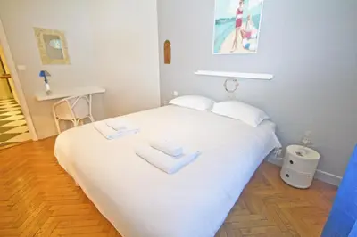 a white bed with two white towels on it at Villa Rivoli City Center Nice in Nice