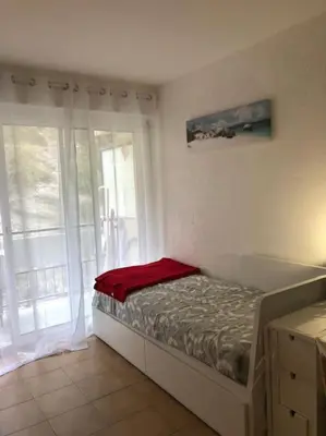 a bedroom with a bed and a large window at Le Rabelais, Studio terrasse in Nice