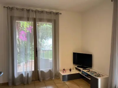 a living room with a television and a window at Nissa la bella, Piscine et vue mer in Nice