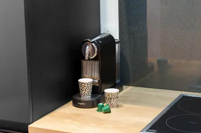 a kitchen counter with a coffee maker and two cups at Nice Renting - ROSSETTI - Modern Haven Heart of Old Nice in Nice