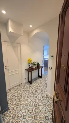 a hallway with a door and a table with flowers on it at Bright, Spacious 2 Bedroom Apartment, Walk to Beach & Old Town in Nice