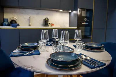 a table with plates and wine glasses on it at Aparthotel 9 ALBERTI Nice Centre in Nice