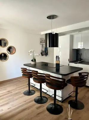 a kitchen with a black table and some chairs at Appartement neuf et rénové promenade des anglais in Nice