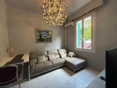 a living room with a couch and a table and a chandelier at Charming house near Center Nice with new air conditioner in Nice