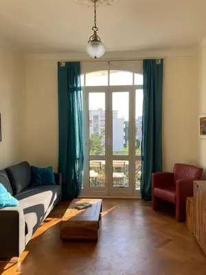 a living room with a couch and a window at Wunderschöne Wohnung in Jugendstilvilla am Hafen in Nice