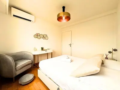 a bedroom with a bed and a chair at Le St Charles in Saint-Laurent-du-Var