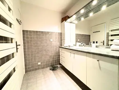 a white bathroom with a sink and a mirror at Le St Charles in Saint-Laurent-du-Var
