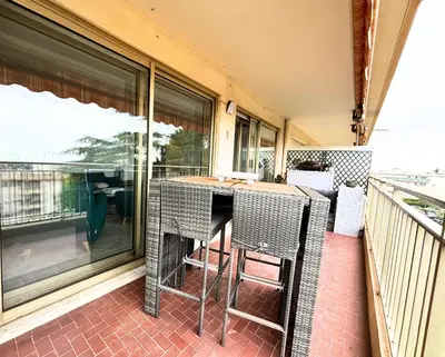a porch with a table and chairs on a balcony at Le St Charles in Saint-Laurent-du-Var