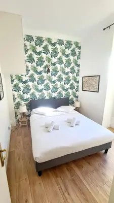 a bedroom with a white bed with a green wall at All new charming 1br hyper centre with balcony and AC in Nice