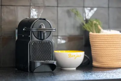 a coffee maker next to a cup on a counter at Soleil de la Buffa - Un joyau central à 3 min des plages in Nice