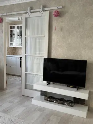 a living room with a flat screen tv on a white entertainment center at Anahit in Nice
