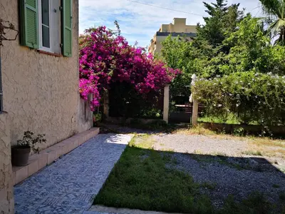 a house with pink flowers next to a building at STUDIO dans Villa à Nice Ouest in Nice