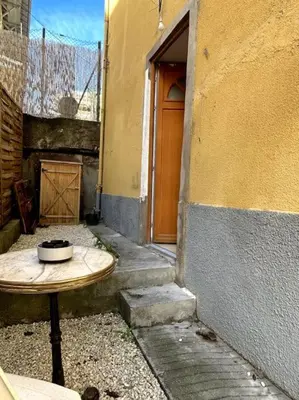 a wooden table sitting next to a building with a door at Charmant studio avec mezzanine in Nice