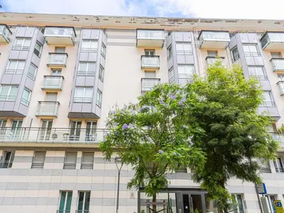 an apartment building with a tree in front of it at Apartment Jardin Pastorelli by Interhome in Nice