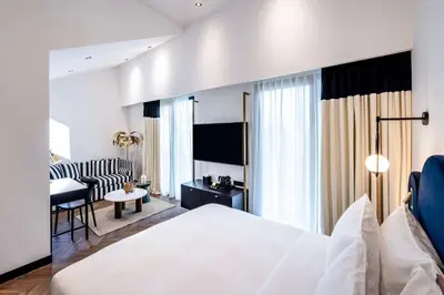 a bedroom with a bed and a living room at Doubletree By Hilton Nice Centre Iconic in Nice
