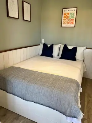a large bed with blue pillows in a bedroom at New apartment with swimming pool in Beaulieu-sur-Mer