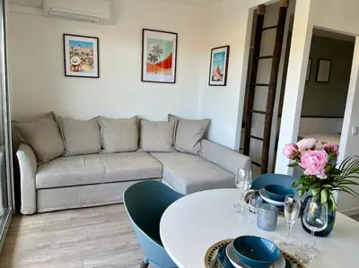 a living room with a couch and a table at New apartment with swimming pool in Beaulieu-sur-Mer