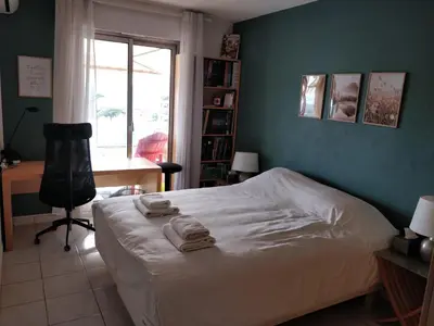a bedroom with a bed and a desk and a window at Chez Gaël, vue mer, piscine, 3chb in Nice