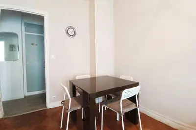 a dining room table with chairs and a clock on the wall at Charming T2 apartment in Nice city center in Nice