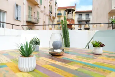 a table with a glass vase and potted plants on it at Nice Renting - BARBERIS - Unique Getaway 2-Room with Rooftop Terrace in Nice