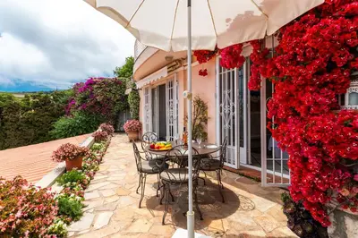 a table and chairs under an umbrella on a patio at ROMANTIC VILLA VI4412 By Riviera Holiday Homes in Villefranche-sur-Mer