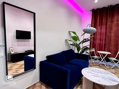 a living room with a blue couch and a table at Luxurious Apartment - Seaside - Spa Bath - WiFi - AC in Nice