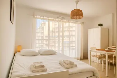 a white table and chairs in a room with a bed at Charming 23 m studio near the sea in Nice