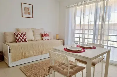 a white kitchen with a white table and chairs at Charming 23 m studio near the sea in Nice