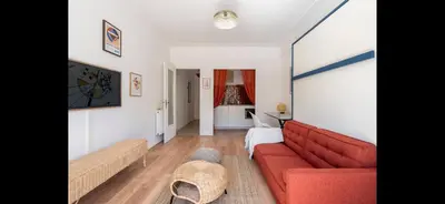 a living room with a red couch and a table at Studio de luxe au cœur de Nice in Nice