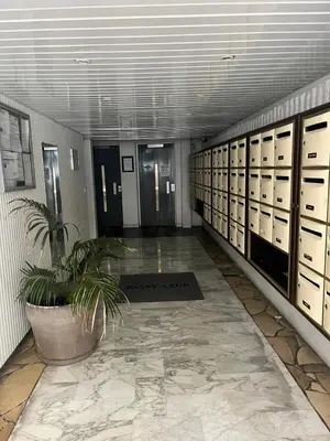 a hallway with lockers and a potted plant in a building at Palm Leaf Studio Nice in Nice