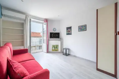 a living room with a red couch and a fireplace at 2P hyper-centre Nice in Nice