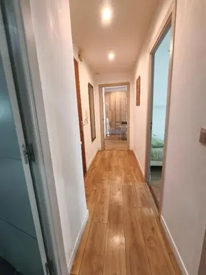 a hallway leading to a room with a hard wood floor at LE MIOLLIS - CENTRAL et CONFORT - WIFI- prés tansports en commun et commerces in Nice