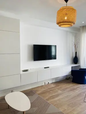 a living room with a tv on a white wall at LE MIOLLIS - CENTRAL et CONFORT - WIFI- prés tansports en commun et commerces in Nice