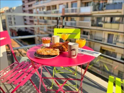 a pink table with food and drinks on a balcony at Studio cosy près du port in Nice