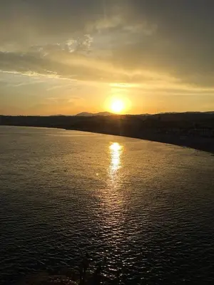 a sun setting over a large body of water at Studio cosy près du port in Nice