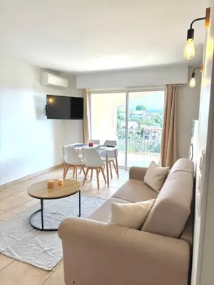 a living room with a couch and a table at DOMAINE LOU BEL AZUR - Harmonie in Saint-Laurent-du-Var