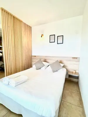 a bedroom with a white bed with two pillows at DOMAINE LOU BEL AZUR - Harmonie in Saint-Laurent-du-Var