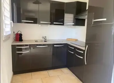 a kitchen with a sink and a black refrigerator at DOMAINE LOU BEL AZUR - Harmonie in Saint-Laurent-du-Var