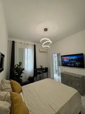 a bedroom with a bed and a tv on the wall at Newly refurbished studio in Nice